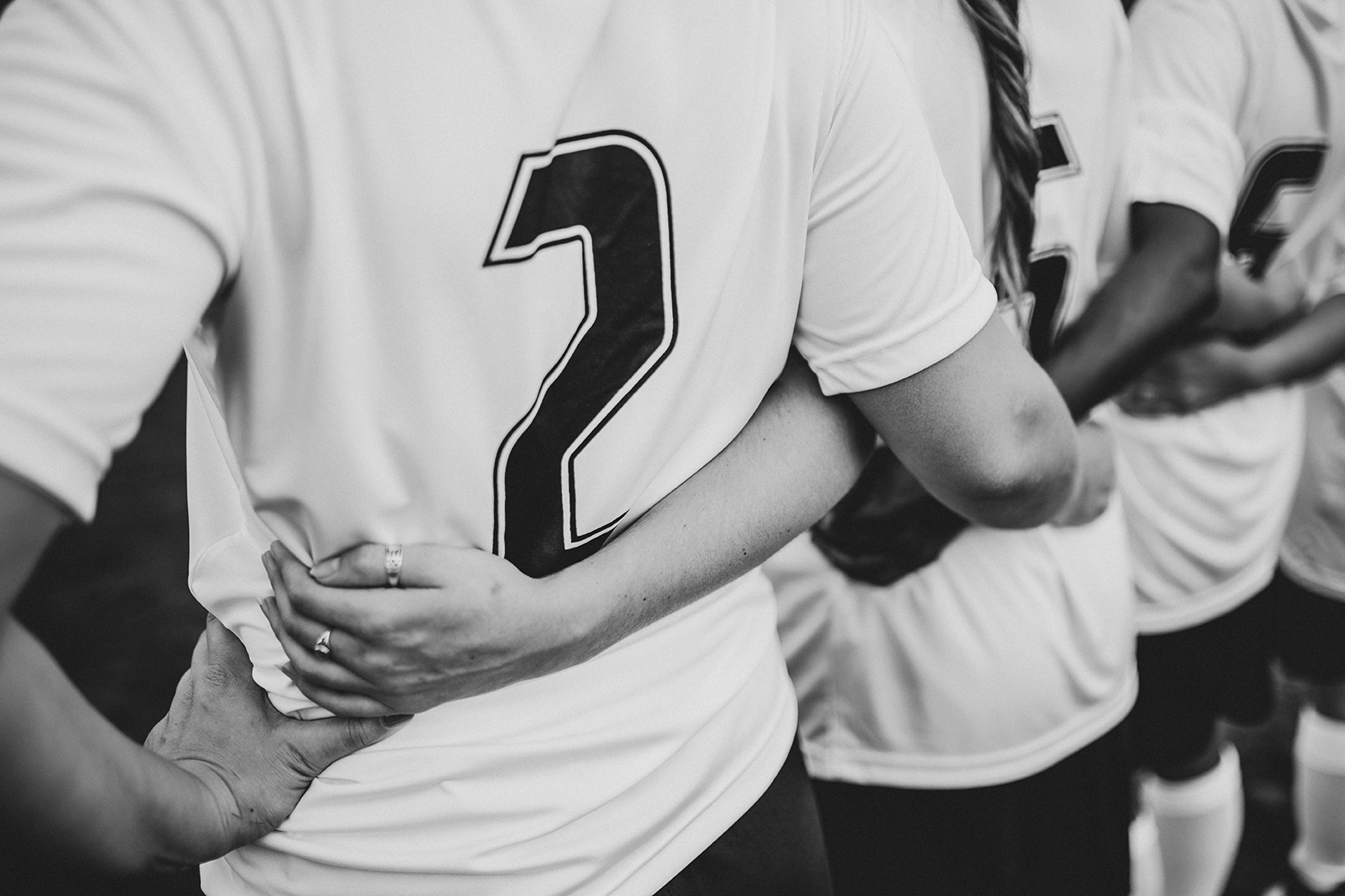 Close up of female football players huddling - Legends Custom Lockers locker rooms